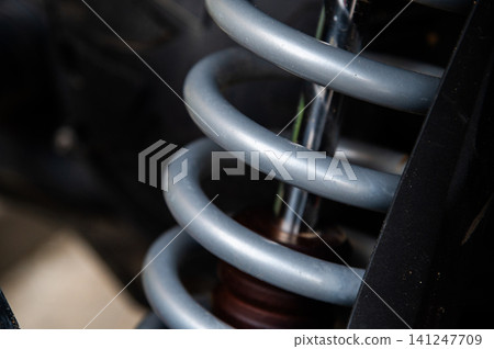 Close-up of automotive coil spring suspension system with metallic finish Close-up of automotive coil spring suspension system with metallic finish 141247709