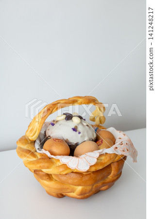 Easter bread basket with decorated cake and eggs on white background Easter bread basket with decorated cake and eggs on white background 141248217