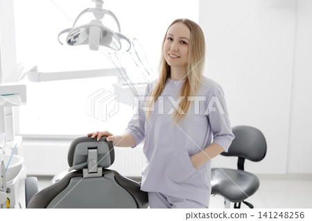 Dentist smiling in her dental office next to equipment Dentist smiling in her dental office next to equipment 141248256