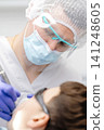 Dentist performing dental checkup on young patient 141248605
