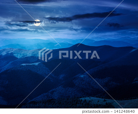 mysterious mountain landscape in summer at night. travel ukraine background. full moon over rolling hill in dappled light. scenic view of borzhava ridge. carpathian mountain scenery 141248640