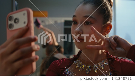 Confident Gymnast Checking Makeup and Taking Selfie in Dress Room Confident Gymnast Checking Makeup and Taking Selfie in Dress Room 141248751