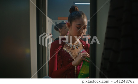 Tired Young Gymnast in Burgundy Crystal Embroidered Costume Opens Locker After Performance Tired Young Gymnast in Burgundy Crystal Embroidered Costume Opens Locker After Performance 141248762