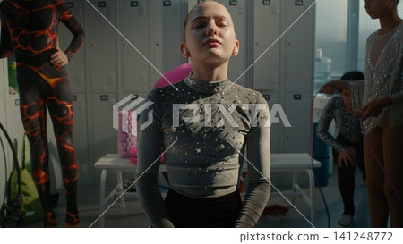 Stressed Teenage Gymnast Putting on Wireless Earphones to Cope with Anxiety Stressed Teenage Gymnast Putting on Wireless Earphones to Cope with Anxiety 141248772