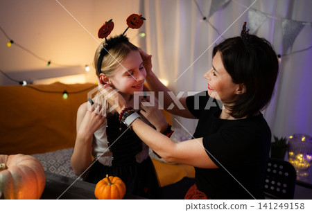 Mother And Daughter Preparing And Dressed For Halloween Celebration Mother And Daughter Preparing And Dressed For Halloween Celebration 141249158