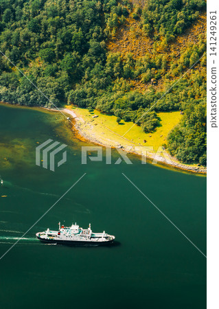 Pleasure boat ship are sailing between fjords. Amazing nature of the Norwegian mountains in Sognefjord. Nature of Norway. Travel concept. Aerial view of a white ferry sailing in a deep green fjord. Pleasure boat ship are sailing between fjords. Amazing nature of the Norwegian mountains in Sognefjord. Nature of Norway. Travel concept. Aerial view of a white ferry sailing in a deep green fjord. 141249261