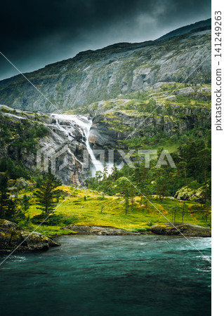 Hiking trail through a pine forest near Kinsarvik. South Fjord, Norway. Giant Waterfall In Valley Of Waterfalls. Husedalen Waterfalls Were A Series Of Four Giant Waterfalls In South Fjord 141249263