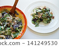 Caesar salad in a white bowl and Caesar salad on a white plate. 141249530