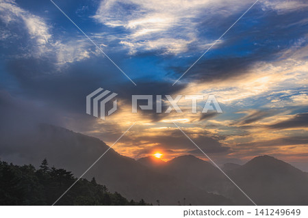A mountain forest in the early morning, where a thin mist hangs over a deep green valley and the shining sun harmonizes beautifully. A mountain forest in the early morning, where a thin mist hangs over a deep green valley and the shining sun harmonizes beautifully. 141249649
