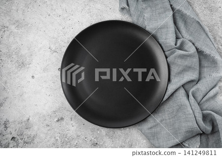 Black Matte Plate with Cutlery on Concrete Background Black Matte Plate with Cutlery on Concrete Background 141249811