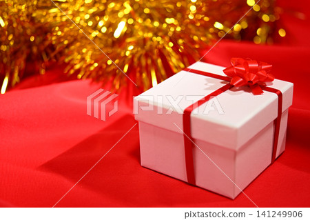一個繫著紅色絲帶的白色盒子，聖誕禮物。 141249906