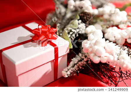 A white box with a red ribbon, a Christmas present. 141249909