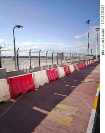 Red and white plastic road safety barriers at the airport. Red and white plastic road safety barriers at the airport. 141250125