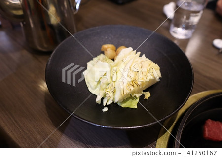 Cabbage and Garnish Dish on Black Plate Cabbage and Garnish Dish on Black Plate 141250167