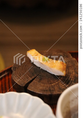 Sliced Fish with Pea Garnish on Wooden Log Sliced Fish with Pea Garnish on Wooden Log 141250186