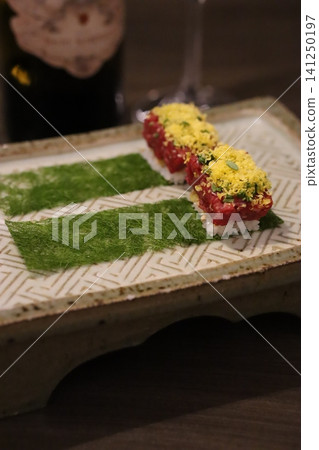 Sushi Rolls with Green Garnish on Decorative Plate 141250197