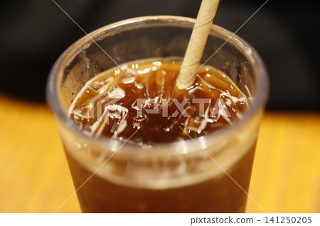 Iced Coffee in Glass with Straw Close-up Iced Coffee in Glass with Straw Close-up 141250205