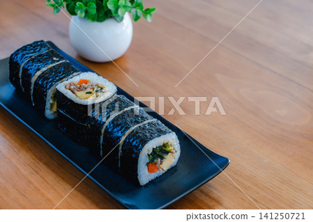 Kimbap, a Korean dish, served on a black plate. Kimbap, a Korean dish, served on a black plate. 141250721
