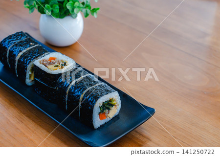 Kimbap, a Korean dish, served on a black plate. Kimbap, a Korean dish, served on a black plate. 141250722