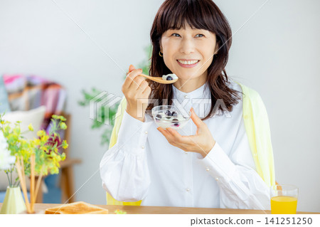 Fermented foods, gut health: Middle-aged women eating yogurt Fermented foods, gut health: Middle-aged women eating yogurt 141251250