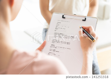一位女士正在聽普拉提工作室的講解 一位女士正在聽普拉提工作室的講解 141251318