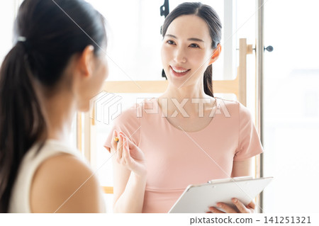 一位女士正在聽普拉提工作室的講解 一位女士正在聽普拉提工作室的講解 141251321