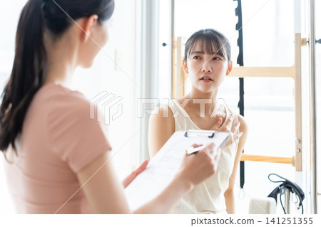 A woman with a troubled expression is being solicited for Pilates. A woman with a troubled expression is being solicited for Pilates. 141251355
