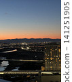 Mountain ranges bathed in the sunset and the city lights at night. 141251905