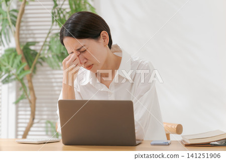 一位四十多歲的女子摀著眼角。 141251906