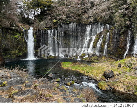 A beautiful waterfall and clear stream cascading down a rocky cliff face. A beautiful waterfall and clear stream cascading down a rocky cliff face. 141251907