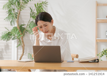 一位四十多歲的女子雙手抱頭。 一位四十多歲的女子雙手抱頭。 141251914
