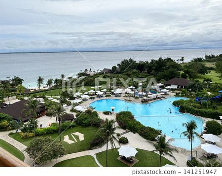 A tropical resort in the Philippines overlooking the ocean and a large swimming pool. A tropical resort in the Philippines overlooking the ocean and a large swimming pool. 141251947