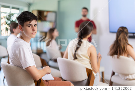 Guy listens and watches a lecture presentation Guy listens and watches a lecture presentation 141252002