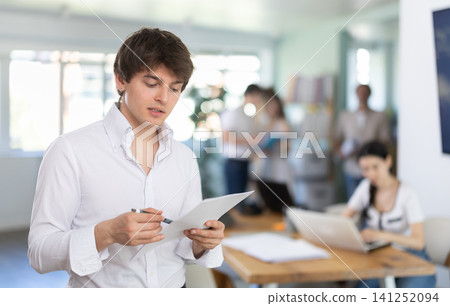 Guy office employees read and process documents. Guy office employees read and process documents. 141252094