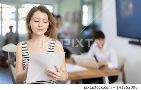 Female worker with a documents in his hands in office Female worker with a documents in his hands in office 141252096