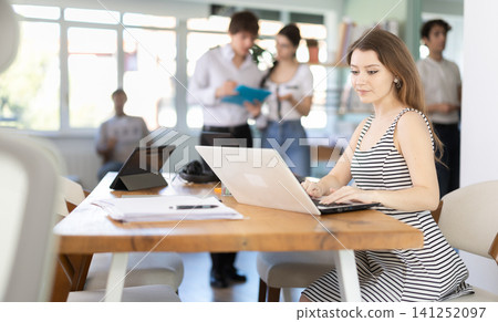 Young woman working on laptop in modern office Young woman working on laptop in modern office 141252097