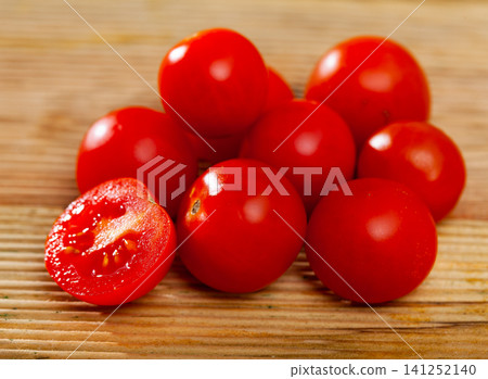 Closeup of ripe red cherry tomatoes on wooden table Closeup of ripe red cherry tomatoes on wooden table 141252140