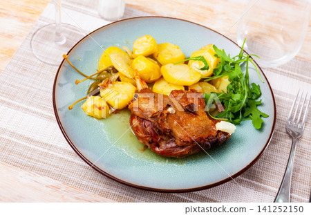 Portion of confit de canard served on plate 141252150