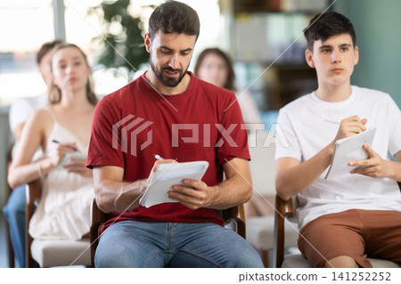 At meeting room during lecture, man visitor listen to teacher At meeting room during lecture, man visitor listen to teacher 141252252