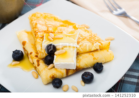 Appetizing pancakes with cheese, honey and nuts Appetizing pancakes with cheese, honey and nuts 141252310