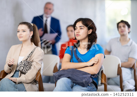 Mature male lecturer in background of classroom, address to young students. Mature male lecturer in background of classroom, address to young students. 141252311