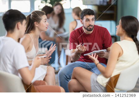 Two teams of young men and women sit in the auditorium, they communicate and discuss Two teams of young men and women sit in the auditorium, they communicate and discuss 141252369