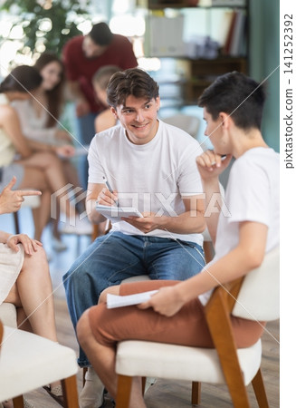 Two teams of young men and women sit in the auditorium, they communicate and discuss 141252392