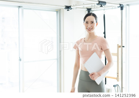 Female Pilates Instructor Female Pilates Instructor 141252396