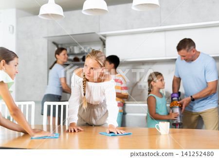 Teenage girls wash dining tables and help to do household chores, family day. Teenage girls wash dining tables and help to do household chores, family day. 141252480