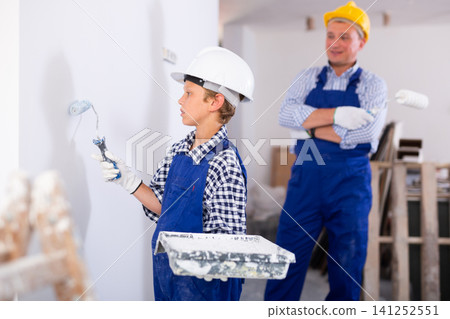 Boy painting wall, renovating home with father Boy painting wall, renovating home with father 141252551