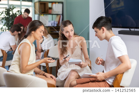 Students have divided into two teams and discussing tactics of debate under teacher guidance Students have divided into two teams and discussing tactics of debate under teacher guidance 141252565