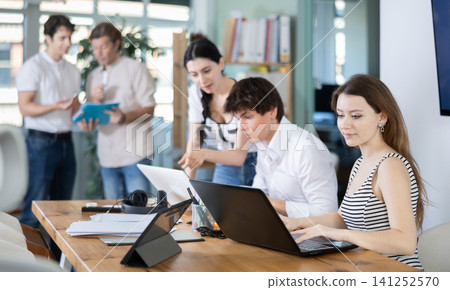 Team of managers work together in a modern office with documents and on Internet Team of managers work together in a modern office with documents and on Internet 141252570