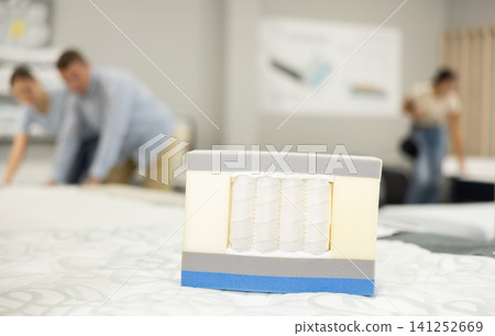 Closeup of mattress cross-section sample lying on bed in furniture store 141252669
