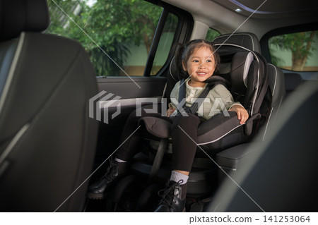 happy preschool child girl sitting in car seat, safety baby chair travelling happy preschool child girl sitting in car seat, safety baby chair travelling 141253064